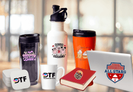 A collection of branded items including a laptop with an "All Stars" logo, a red book, mugs, tumblers, and a water bottle featuring various designs and logos, arranged on a blurred background.